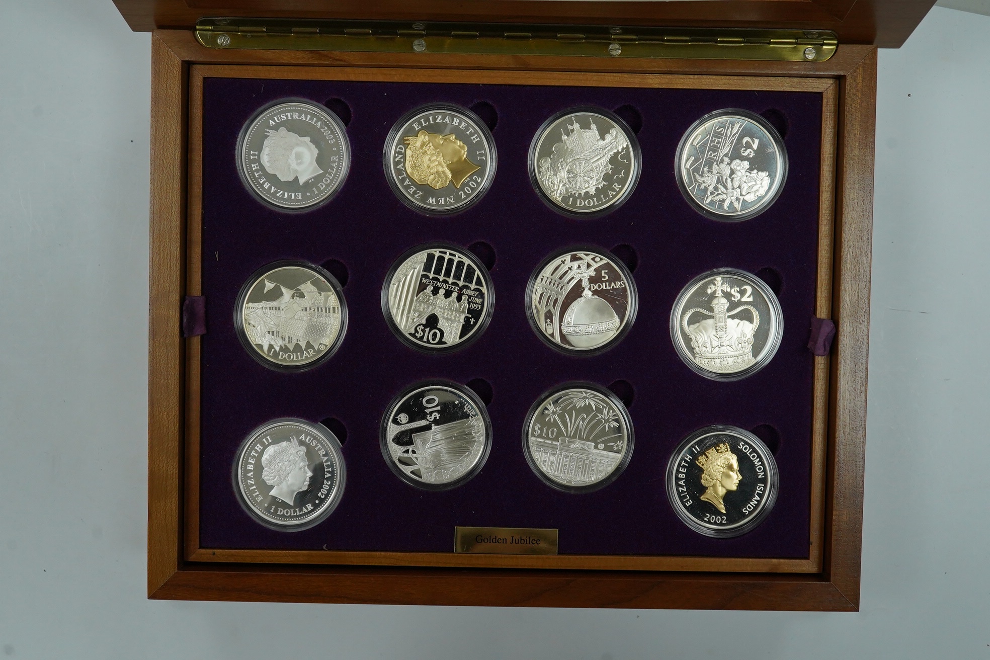 Royal Mint UK QEII Golden Jubilee collection of 24 silver proof coins, 2002, each 28.28g, in wood case fitted with two trays, with individual certificates and album